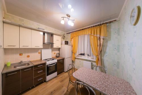 cocina pequeña con mesa, fregadero y fogones en Апартаменты на Бирули от ApartmentCity, en Mogilev