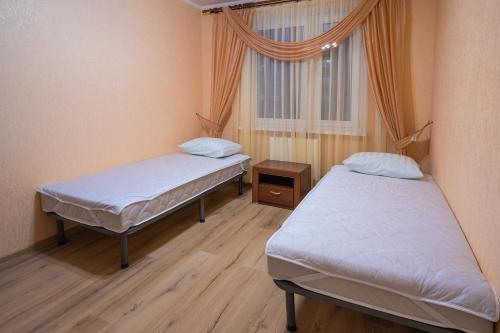 2 camas en una habitación con ventana en Апартаменты на Бирули от ApartmentCity, en Mogilev