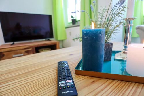 a remote control and a candle on a table at MD-8 Kleiststrasse 4 - Zentral nur 5min bis zur Innenstadt - 2Schlafzimmer-Smart TV-Badewanne-Innenhoflage in Magdeburg