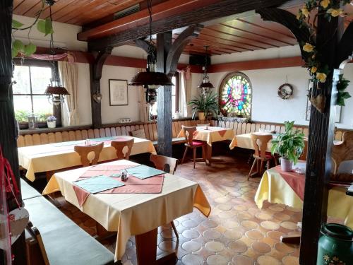 ein Restaurant mit Tischen und Stühlen und einem Buntglasfenster in der Unterkunft Hotel Landgasthof Ratz in Rheinau