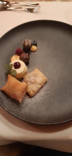 a black plate of food on a table at Hotel St-Leonhard in Sankt Leonhard im Pitztal