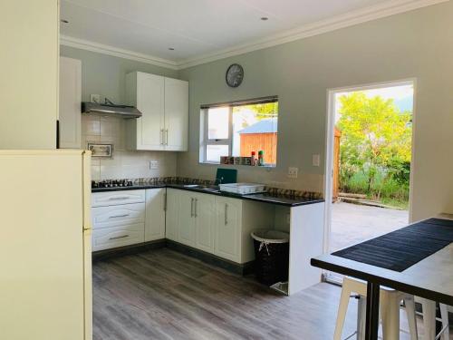una grande cucina con armadi bianchi e una finestra di Habitat a Clarens