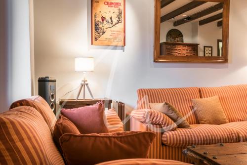 a living room with two couches and a mirror at Amitges by SeaMount Rentals in Baqueira-Beret