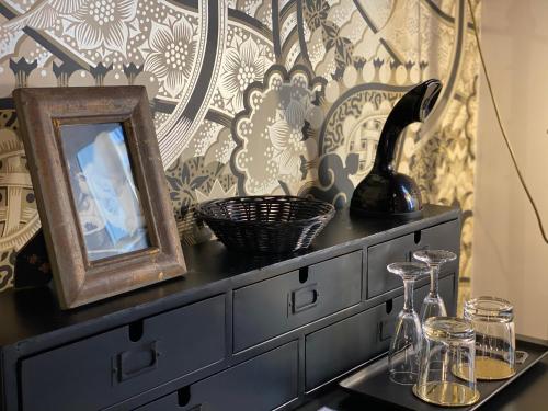 a black dresser with a mirror and a picture on it at Frattina 57 in Rome