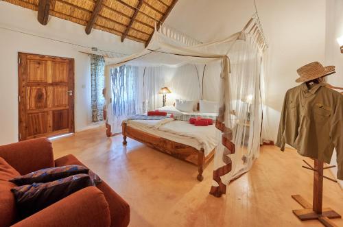 una camera con letto a baldacchino e divano di Wild Dogs Lodge a Lusaka