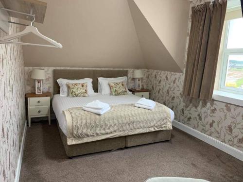 a bedroom with a bed with two towels on it at No. 1 Charlotte Street in Port Ellen