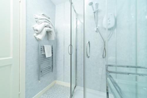 La salle de bains est pourvue d'une douche avec une porte en verre. dans l'établissement The Foresters Guest House, à Inverkip