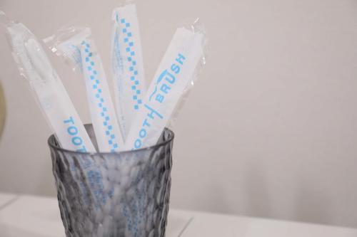 a glass vase with toothbrushes in it at ケイアイコンホテルズ 池下 in Chikusachō