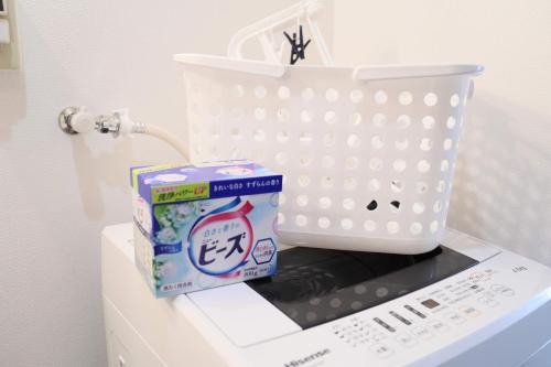 a white basket and a box of milk on a refrigerator at ケイアイコンホテルズ 池下 in Chikusachō