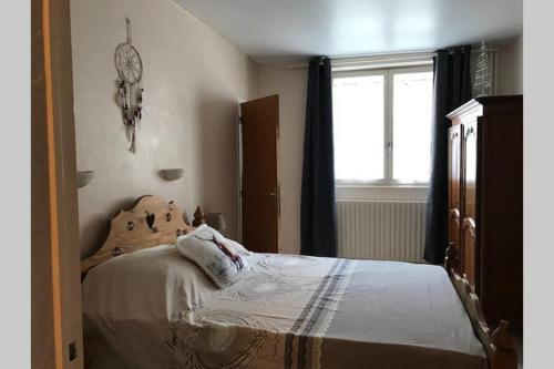 1 dormitorio con cama y ventana en Appartement 4 personnes avec Wifi Centre La Bourboule, en La Bourboule