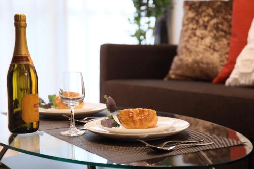 a table with a plate of food and a bottle of wine at ケイアイコンホテルズ 池下 in Chikusachō