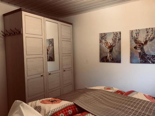 a bedroom with a bed and some pictures on the wall at Landhaus Krappinger in Bad Kleinkirchheim