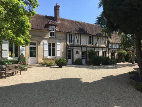 une vieille maison avec un banc devant elle dans l'établissement Le Puits D'Angle, à Thibivillers