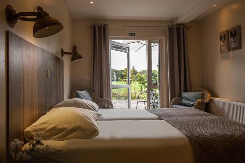 um quarto com uma cama grande e uma janela em Herberg de Appelgaard em Barneveld
