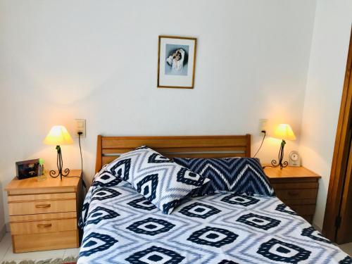 a bedroom with a bed and two night stands with lamps at MEDDAYS VILLA HORUS CON PISCINA PRIVADA in Miami Platja