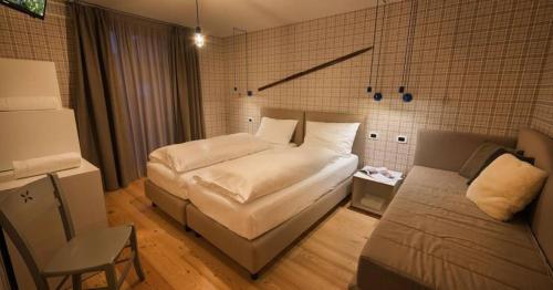 a bedroom with a bed and a couch in it at Cronox Vinecc in Livigno