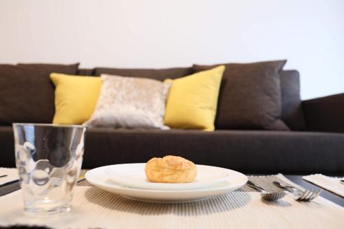 a plate with a donut on a table with a couch at ケイアイコンホテルズ 池下 in Chikusachō