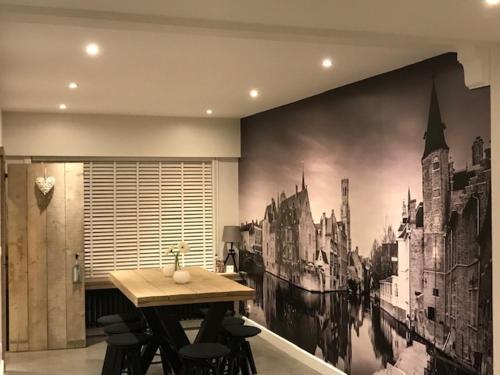 a dining room with a large painting on the wall at Vakantiewoning Margaux -free parking - Sauna in Bruges
