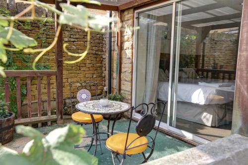 a patio with a table and two chairs and a bed at Volunteer Inn in Chipping Campden