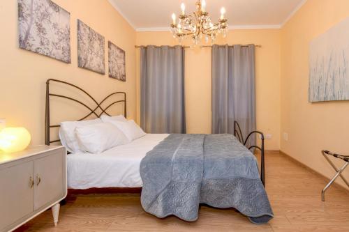 a bedroom with a bed and a chandelier at Colleincanto Appartamento Mercedes in Gavardo