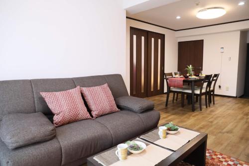 a living room with a couch and a table at ケイアイコンホテルズ 池下 in Chikusachō