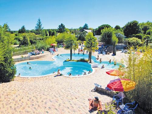 un groupe de personnes dans une piscine d'un complexe hôtelier dans l'établissement Mobil Home XXL2 4 chambres - Camping Les Bois du Bardelet, à Poilly-lez-Gien