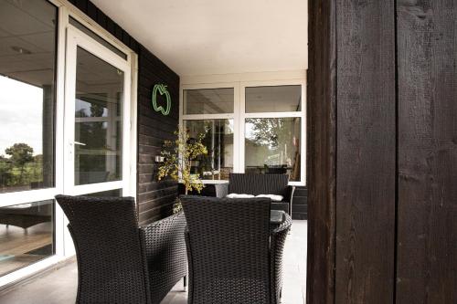 a patio with chairs and a table and windows at Herberg de Appelgaard in Barneveld