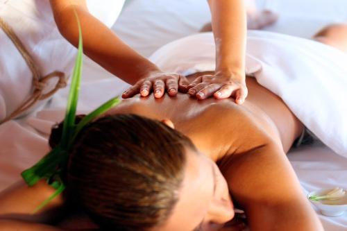 a woman getting a massage from a man on a bed at Pullman Eindhoven Cocagne in Eindhoven