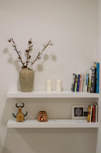 a white shelf with a vase and some books at הבית של סתיו in Rosh Pinna