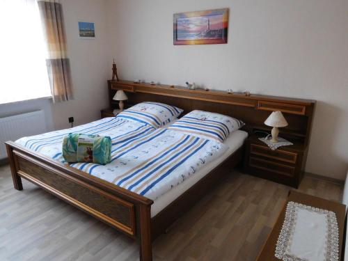 a bedroom with a large bed with a wooden headboard at Ferienwohnung-Kuestensnack in Cuxhaven
