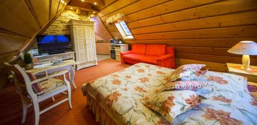 a bedroom with a bed and a television in a cabin at Leśny Dworek Zakopane in Zakopane
