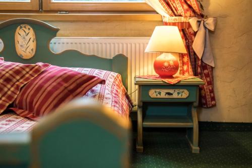a bedroom with a bed and a table with a lamp at Leśny Dworek Zakopane in Zakopane