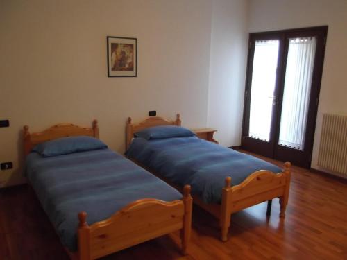 two twin beds in a room with a window at Sentiero Valinis in Fanna