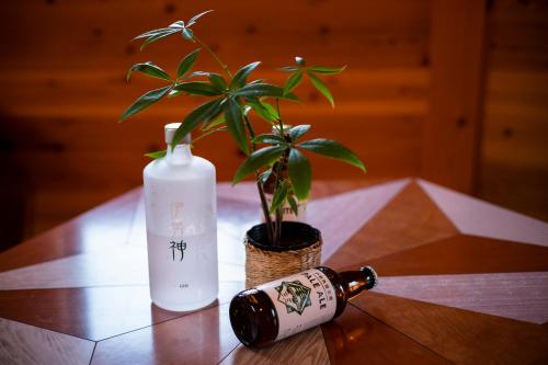a table with a plant and a bottle on it at Ise Guest House Kazami in Ise