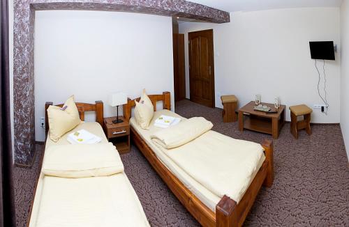 a hotel room with two beds and a table at Becsi Szelet in Miercurea-Ciuc