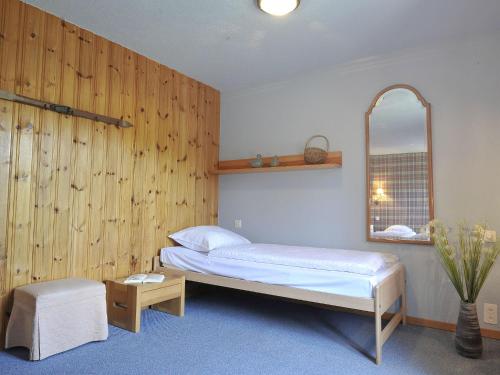 a bedroom with a bed and a mirror at Chalet Chalet le Chamois by Interhome in Moleson