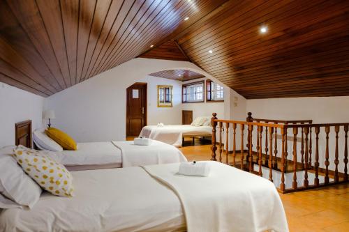 a bedroom with two beds and a wooden ceiling at Classico Guesthouse in Vila Nova de Gaia
