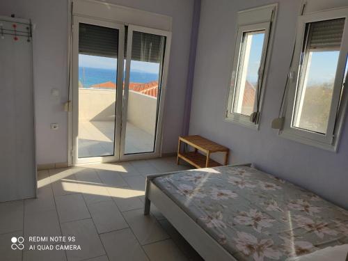a bedroom with a bed and a view of the ocean at Fotis Apartments in Skála Néon Kydonión