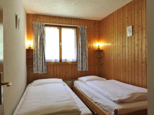 two beds in a room with a window at Chalet Mountain View by Interhome in Moleson