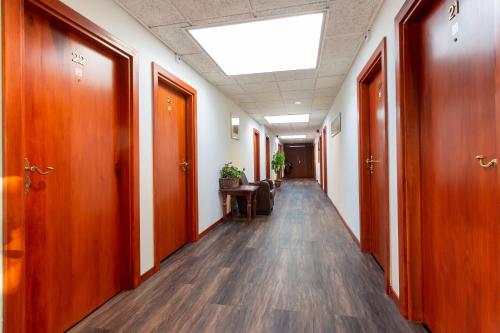 an empty corridor of an office with wooden doors and a table at Het Wapen van Leiden in Appingedam