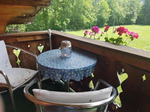 グスタードにあるApartment Steimandli by Interhomeの花の咲くバルコニー(青いテーブル、椅子付)