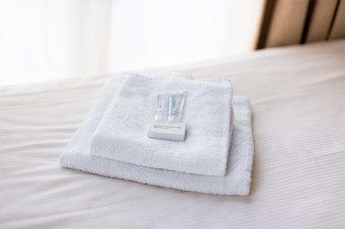 a pile of white towels sitting on a bed at Het Wapen van Leiden in Appingedam