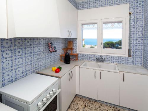 リャンサにあるApartment Geranis by Interhomeの白いキャビネット、シンク、窓付きのキッチン