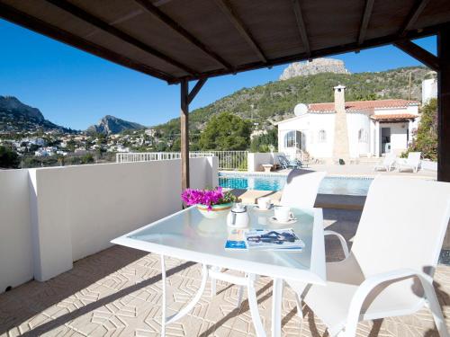 a white table and chairs on a balcony with a view at Villa Bougainvillea by Interhome in La Canuta