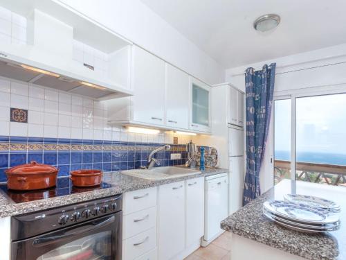 リャンサにあるHoliday Home Niviroma by Interhomeの白いキャビネット付きのキッチン、海の景色を望む