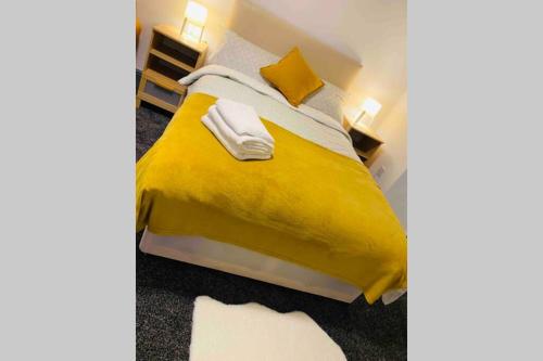 1 dormitorio con 1 cama con sábanas y almohadas amarillas en Swansea house en Birmingham