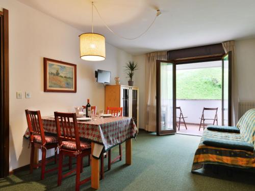 ein Wohnzimmer mit einem Tisch und Stühlen sowie ein Esszimmer in der Unterkunft Apartment Enrosadira-5 by Interhome in Alba di Canazei