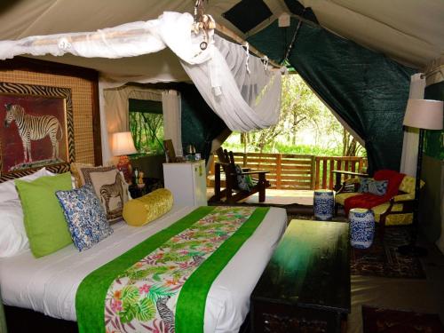 a bedroom with a bed in a tent at Wielewaal Bush Lodge in Marloth Park