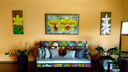 a couch in a room with paintings on the wall at Quiriri Park Hotel in Prado