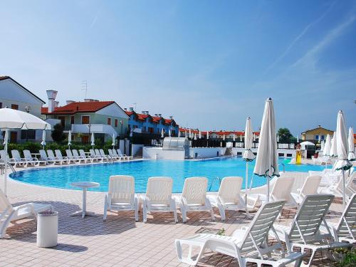 a group of chairs and umbrellas next to a swimming pool at Apartment Mediterraneo-3 by Interhome in Rosapineta